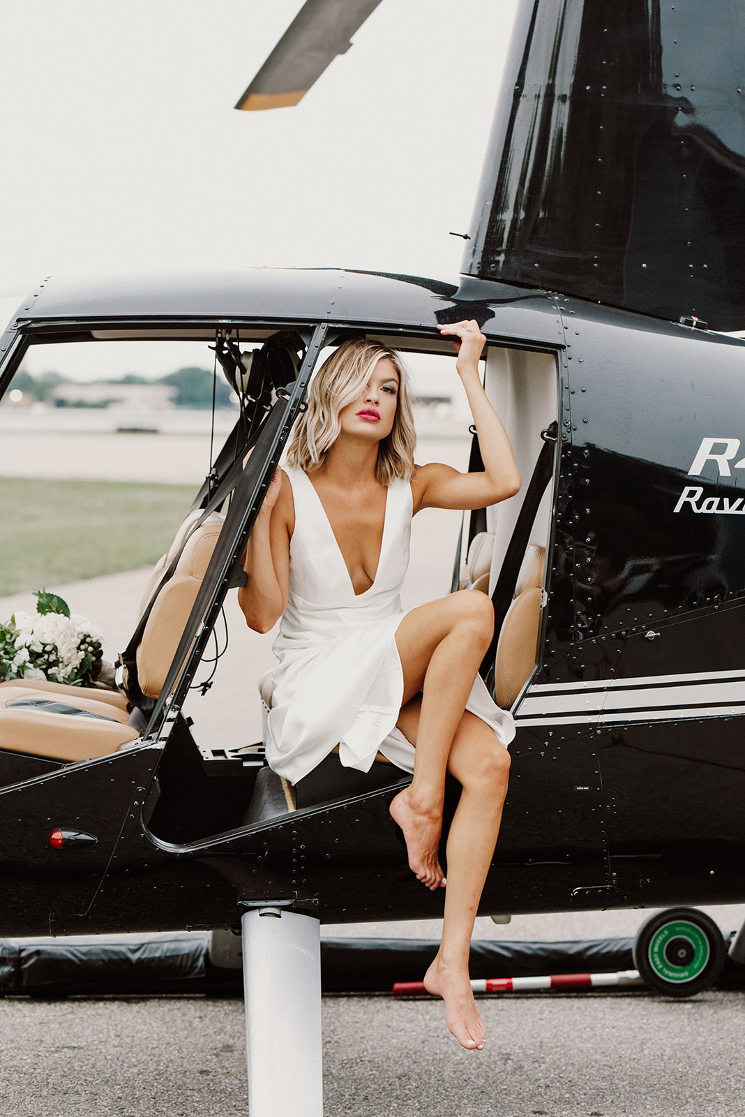 Bride posing on a black helicopter, taken by Mary Shelton Media