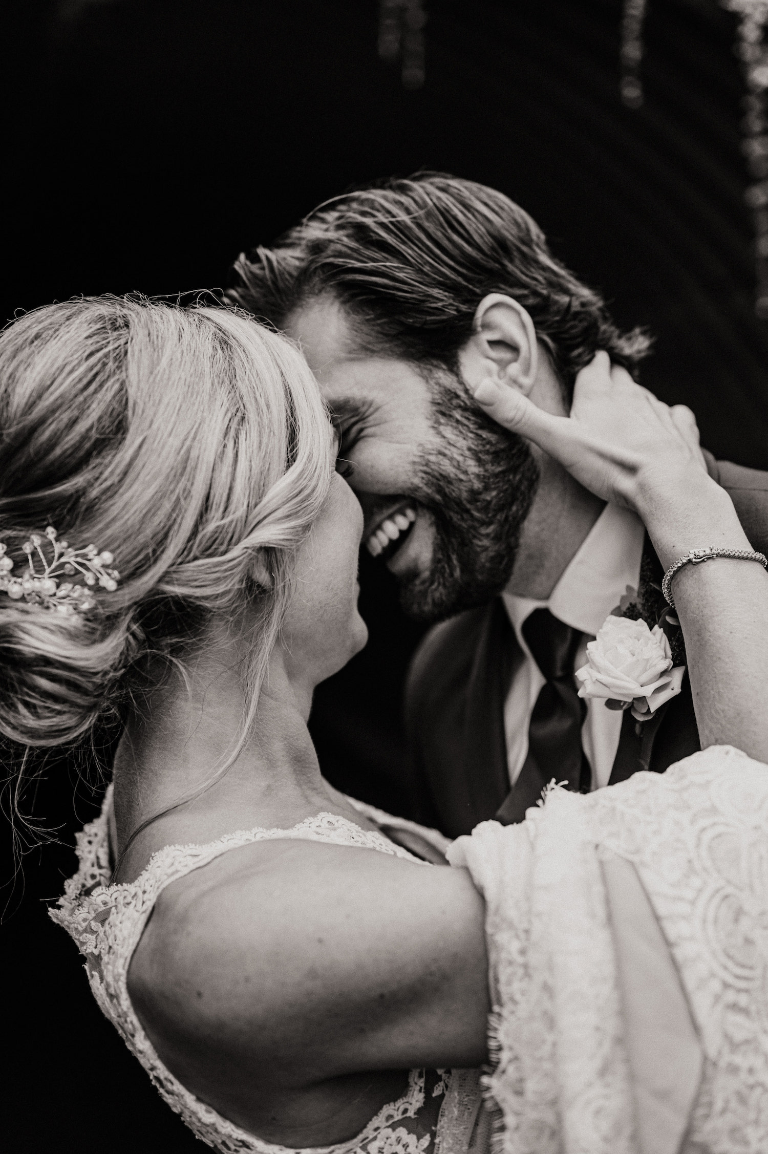 Black and white photo of the bride and groom laughing and leaning in to each other, taken by Michigan wedding photographer Mary Shelton